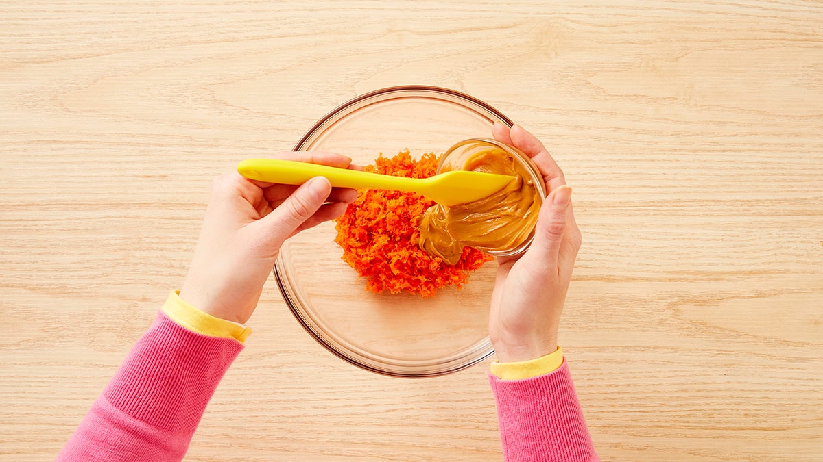 In the large mixing bowl, combine the remaining coconut oil with the shredded carrots, peanut butter, pumpkin and egg.