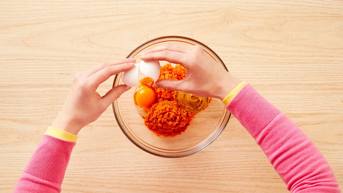In the large mixing bowl, combine the remaining coconut oil with the shredded carrots, peanut butter, pumpkin and egg.