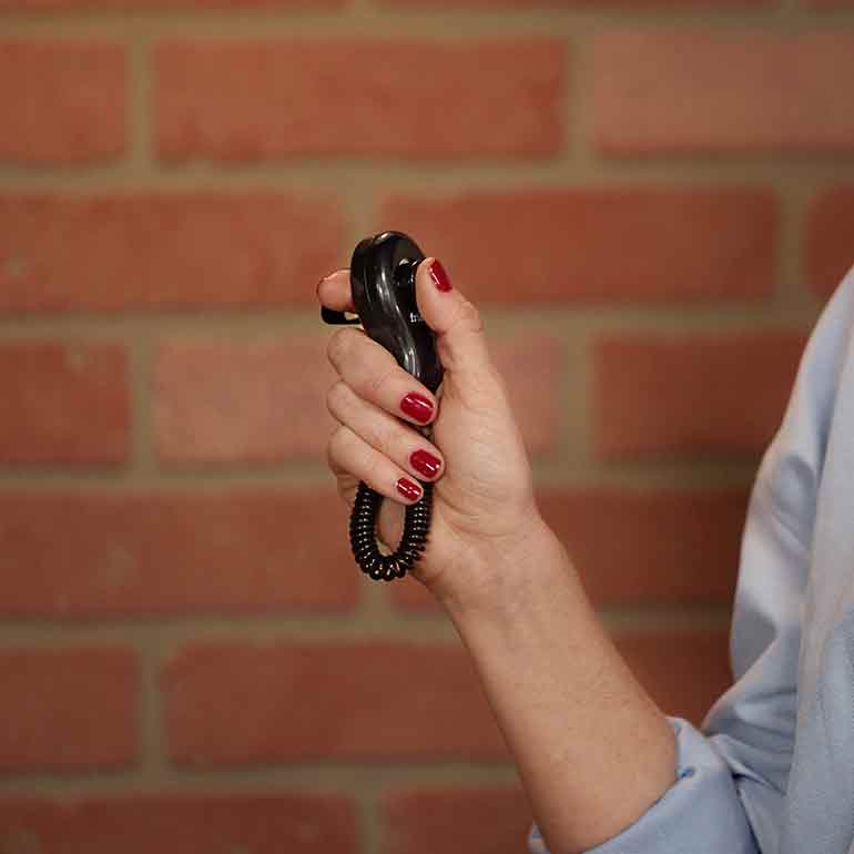 Photo of a woman holding a training clicker in her hand