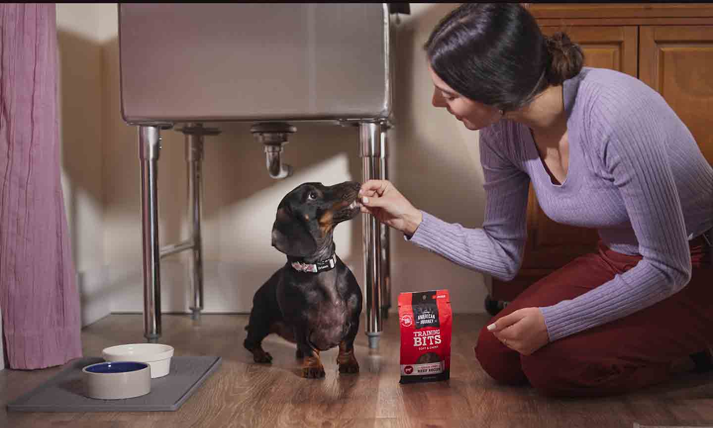 Photo of a woman giving a dog a treat