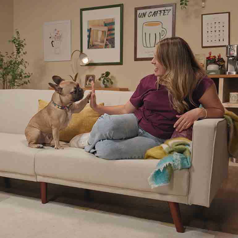 Photo of a woman sitting beside her dog on a couch